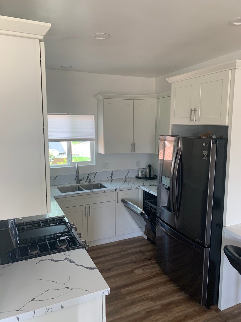 Finished kitchen with white shaker cabinets and stainless appliances